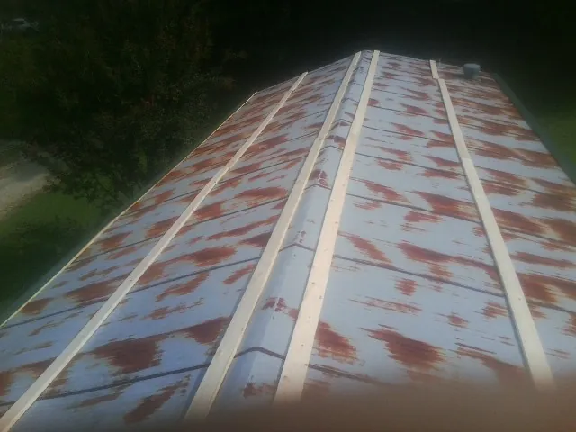 Rusted metal roof panels with new wood purlins before replacement — Storm Damage Roof Repair in Bayport by Roofing Brothers