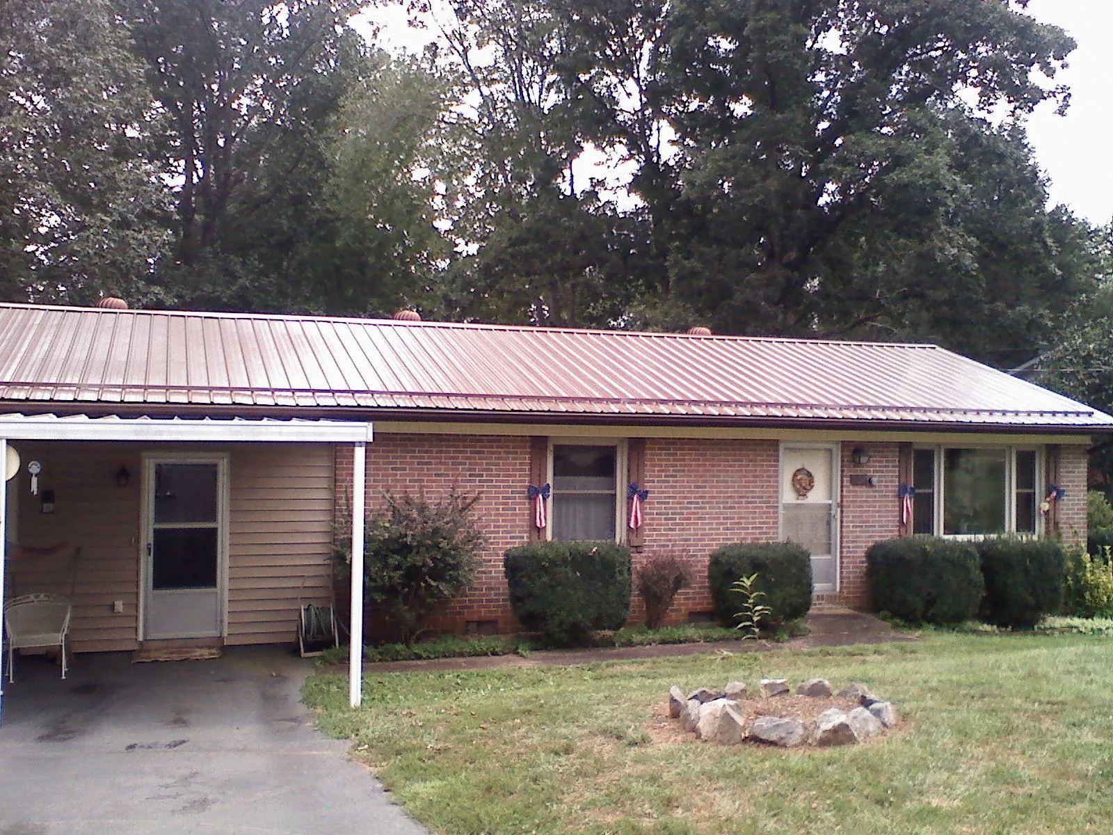 Bronze metal roof and carport on a brick ranch home — Roof Repair work by our crew in Bayport